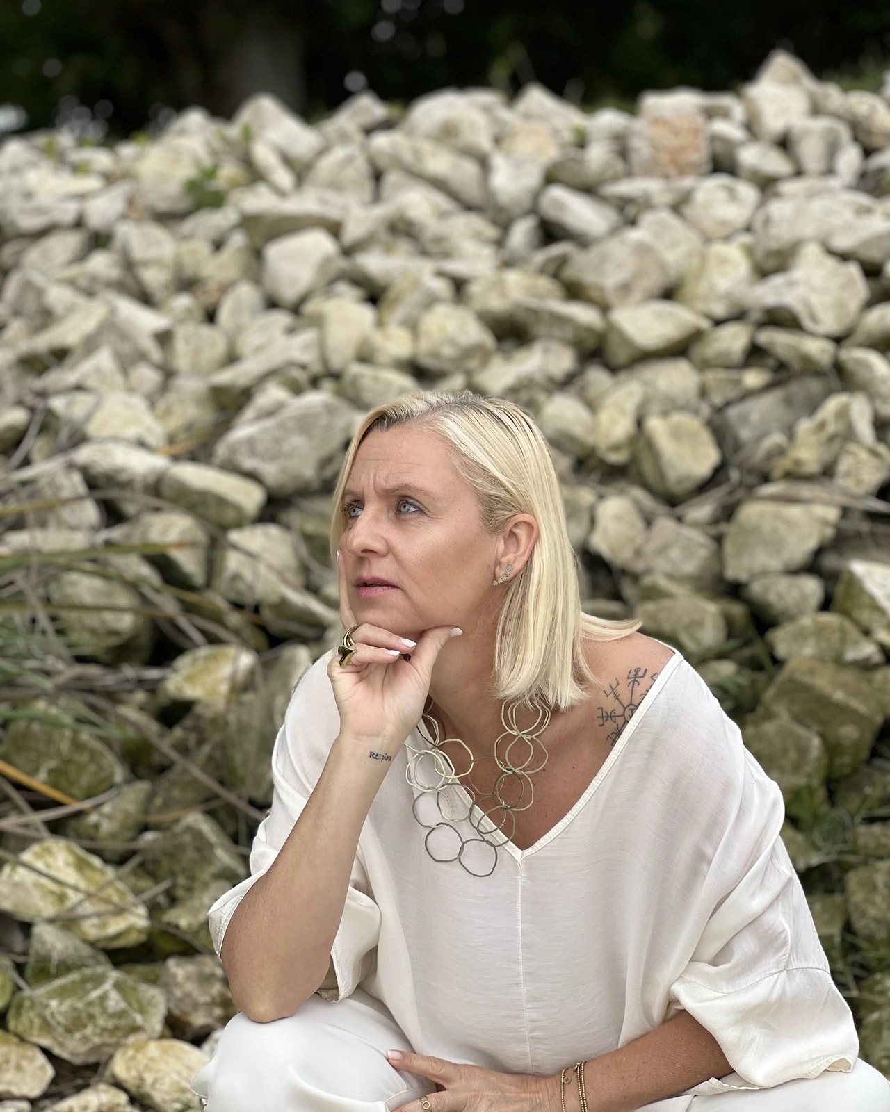 Hortênsia Monteiro, pensativa, junto a um muro de pedra