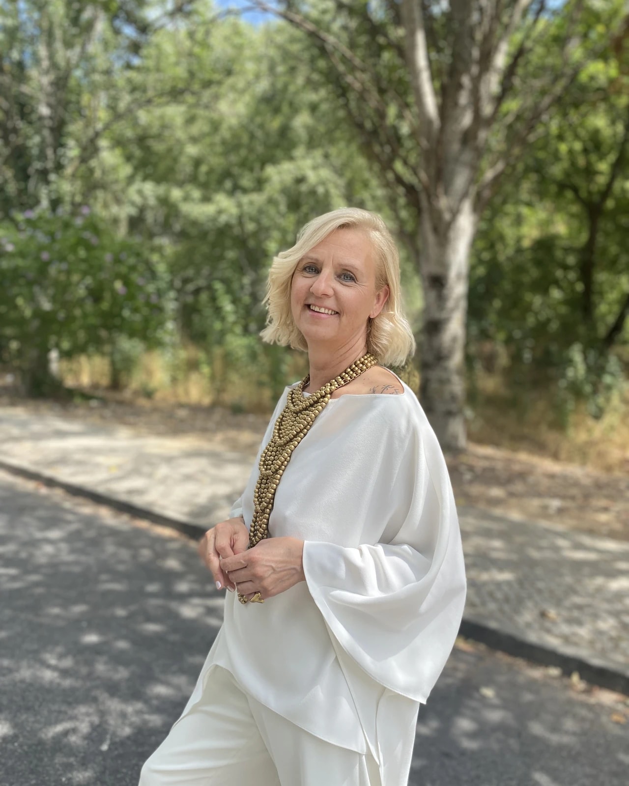 Hortênsia Monteiro a sorrir, de branco, ao ar livre